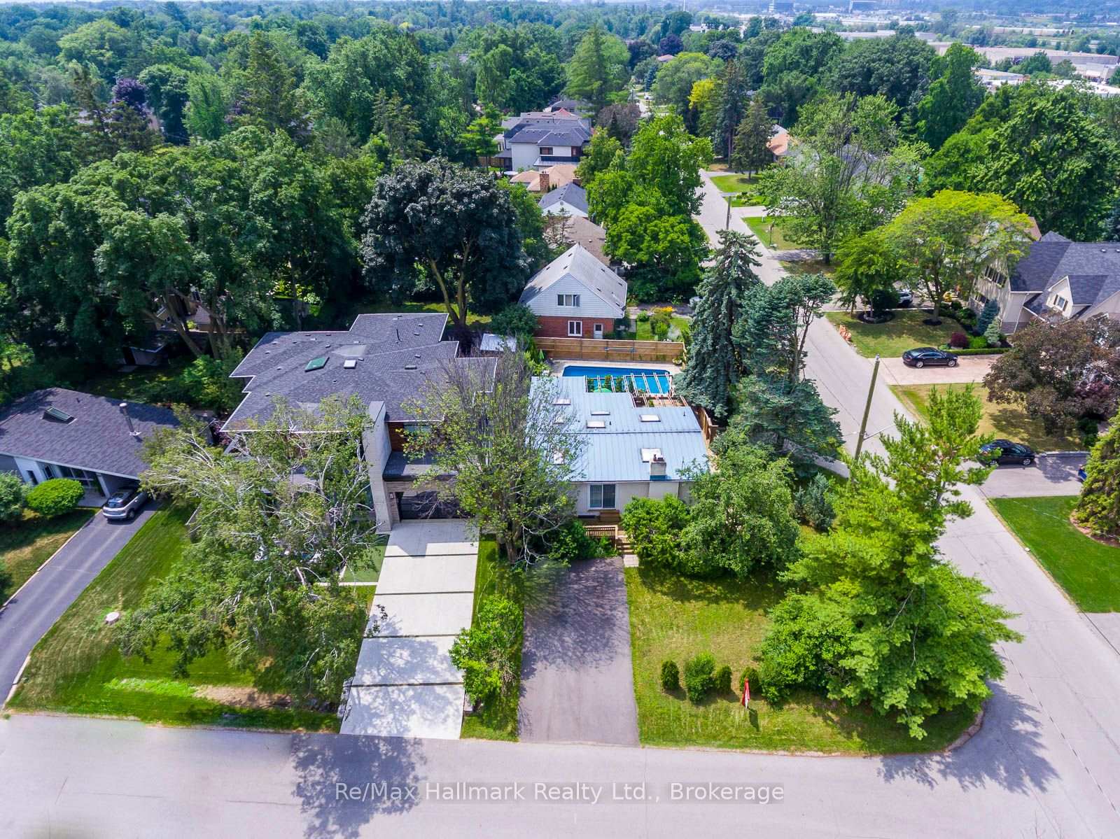 Aerial view of a tree-lined Oakville home with a backyard swimming pool.