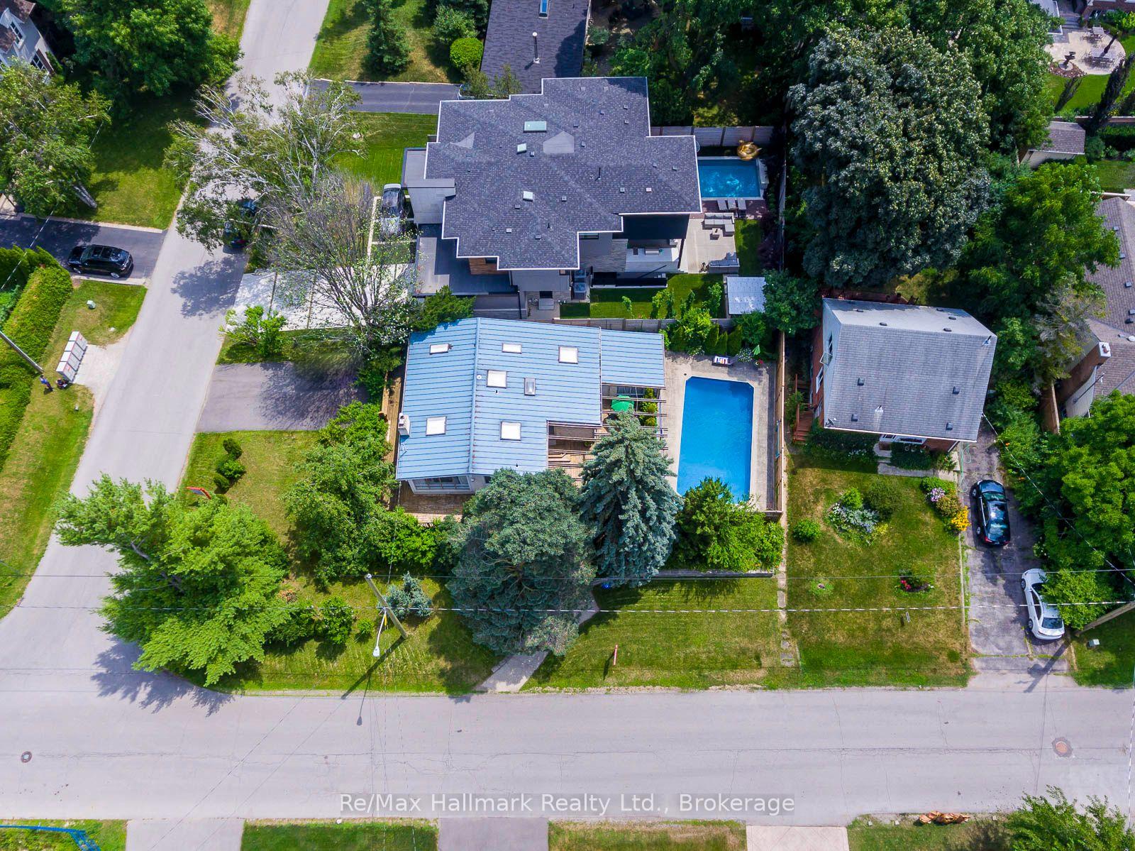 Aerial view of homes with backyard swimming pools, mature trees, and landscaped yards.
