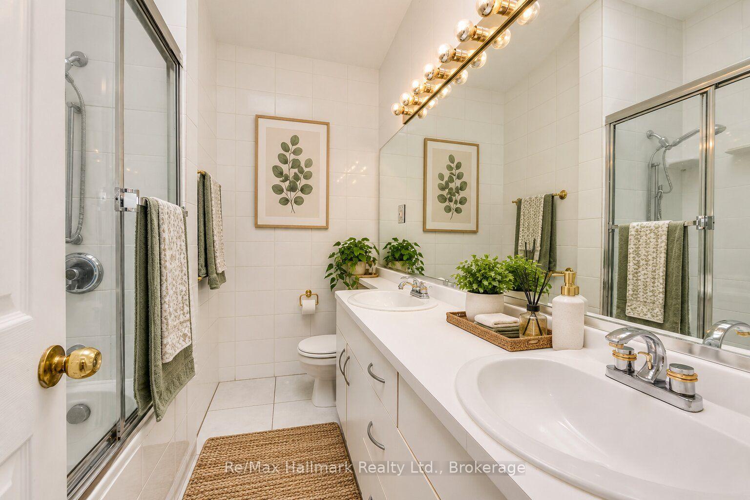Bright tiled bathroom with a double vanity, large mirror, and glass-enclosed shower.