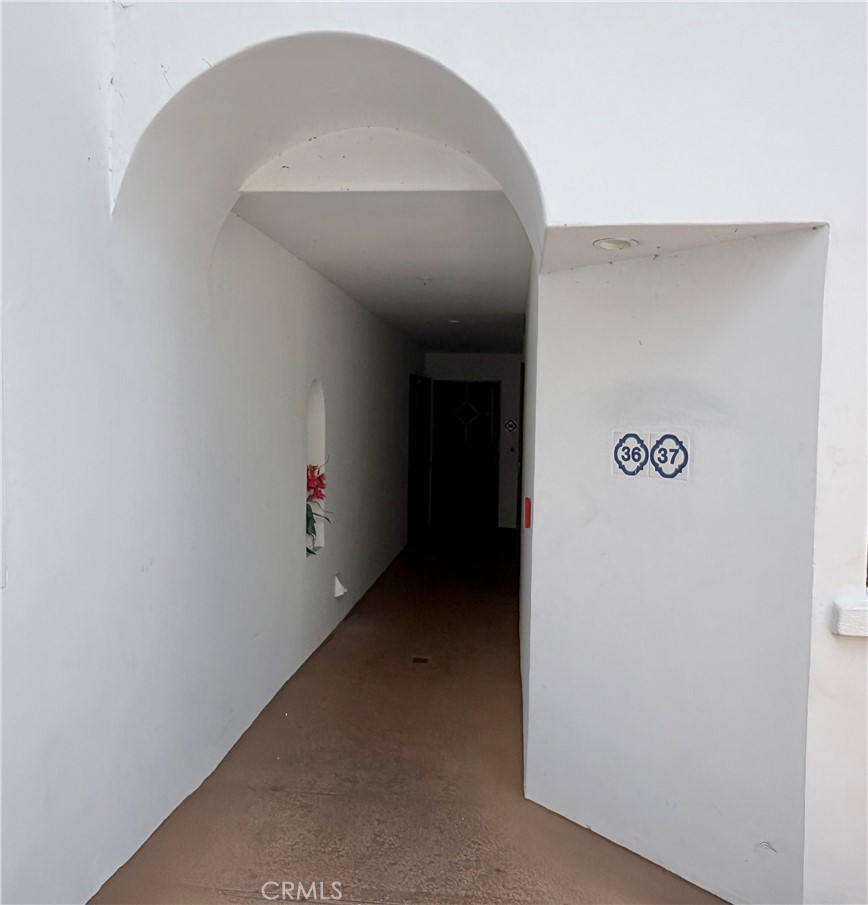 Covered arched entry corridor with unit numbers 36 and 37 on the wall.