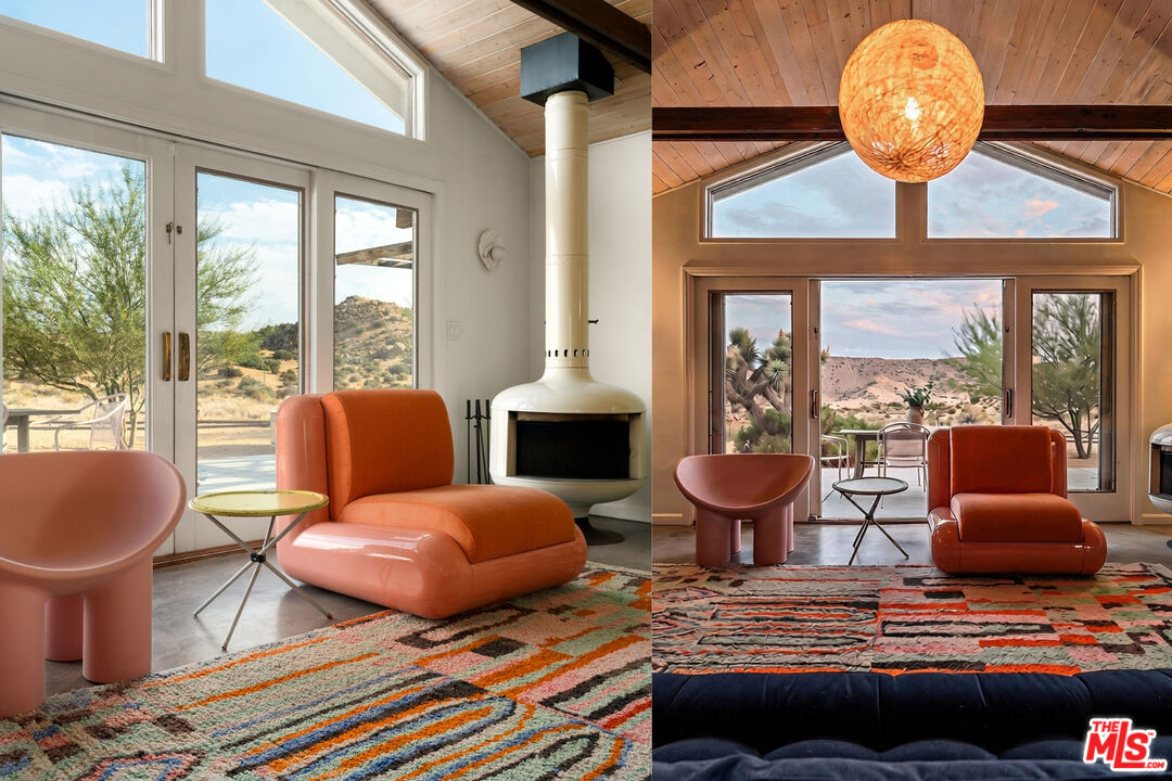 Living room with sculptural orange seating, a freestanding fireplace, and expansive windows overlooking the desert.