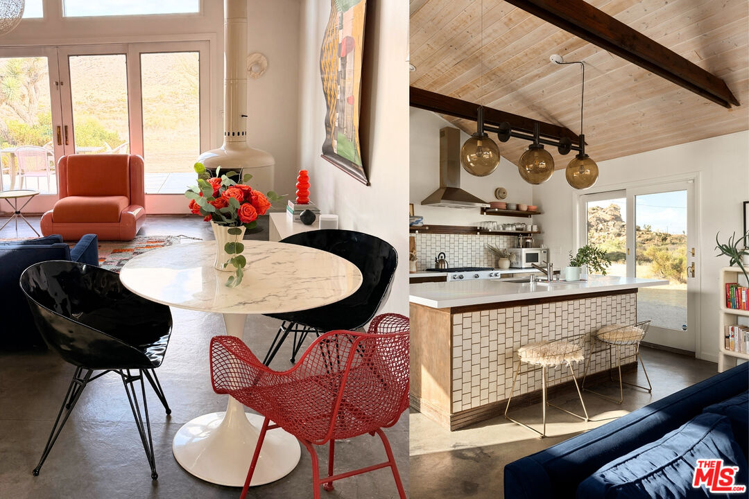 Dining and living area beside a kitchen with a tiled island and vaulted wood ceiling.