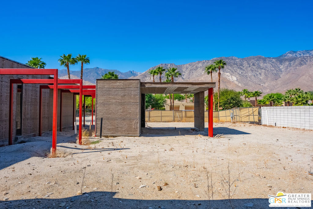 Partially constructed property with red steel framing and mountain views.