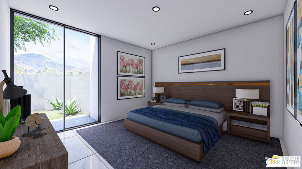Modern bedroom with dark blue bedding and sliding glass doors overlooking a patio and mountain.