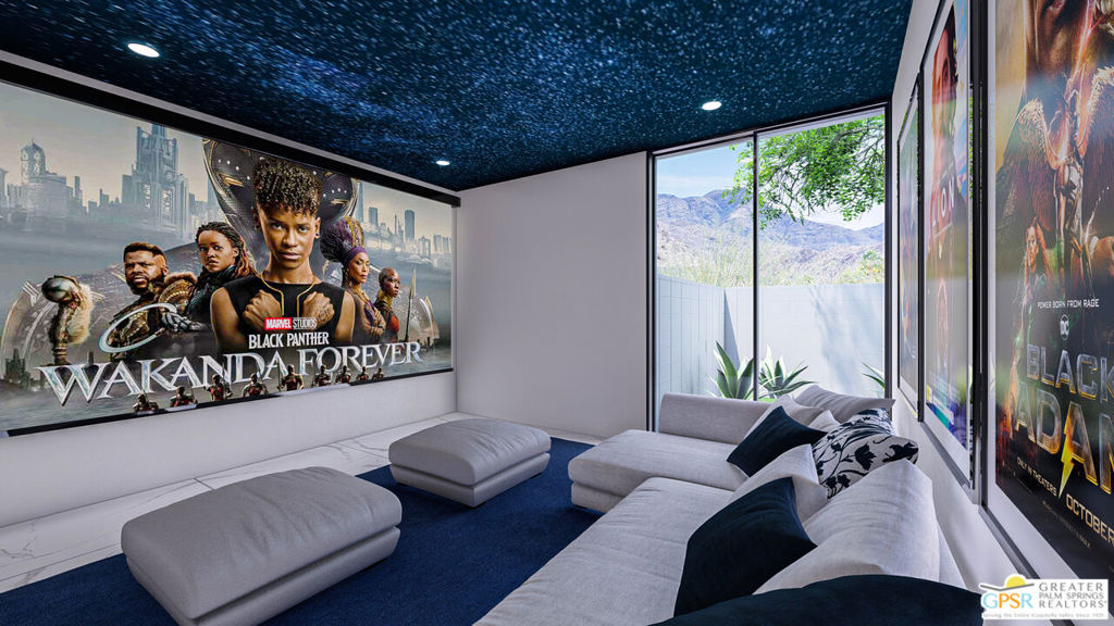 Media room with a gray sectional, Black Panther posters, and mountain views through large windows.