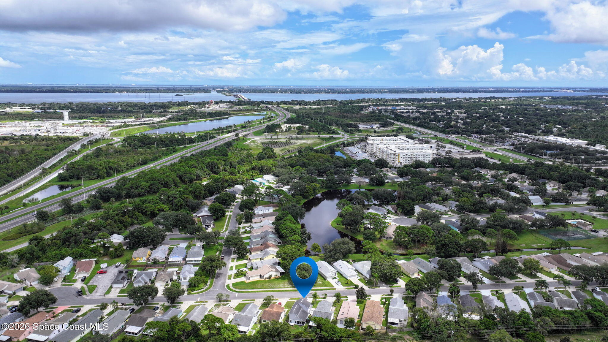 Aerial view of the neighborhood and nearby water, with a location marker over the home.