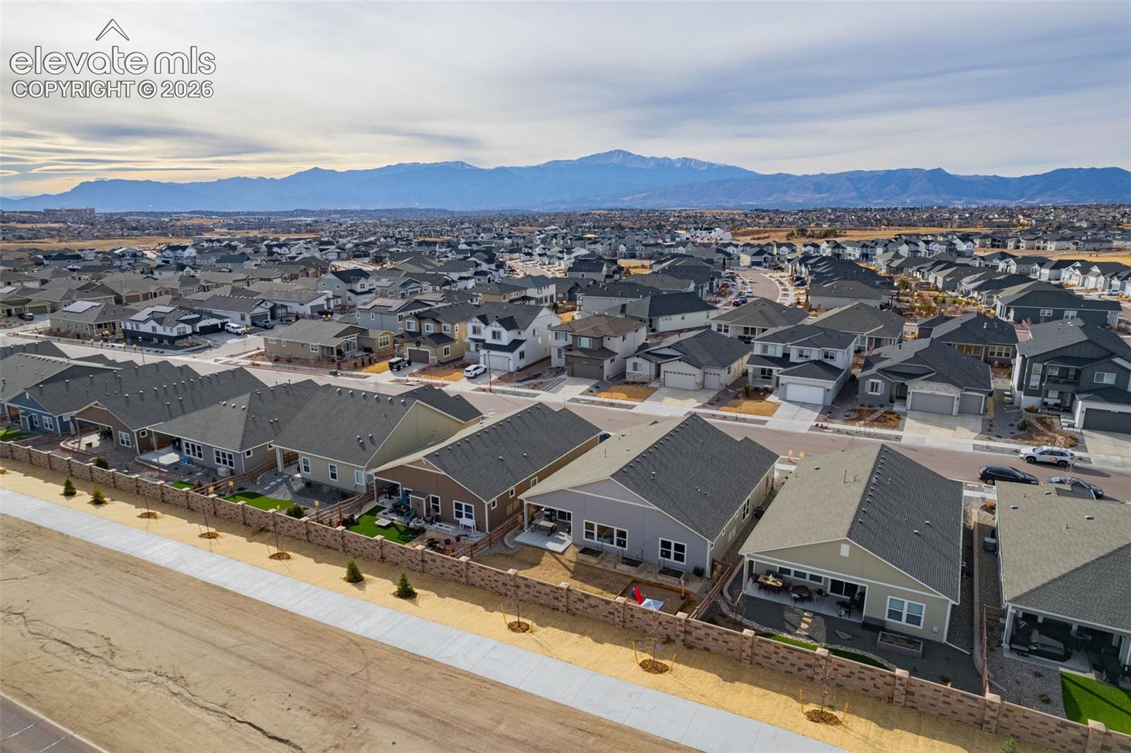 Aerial view of a residential neighborhood with the Rocky Mountains in the distance.