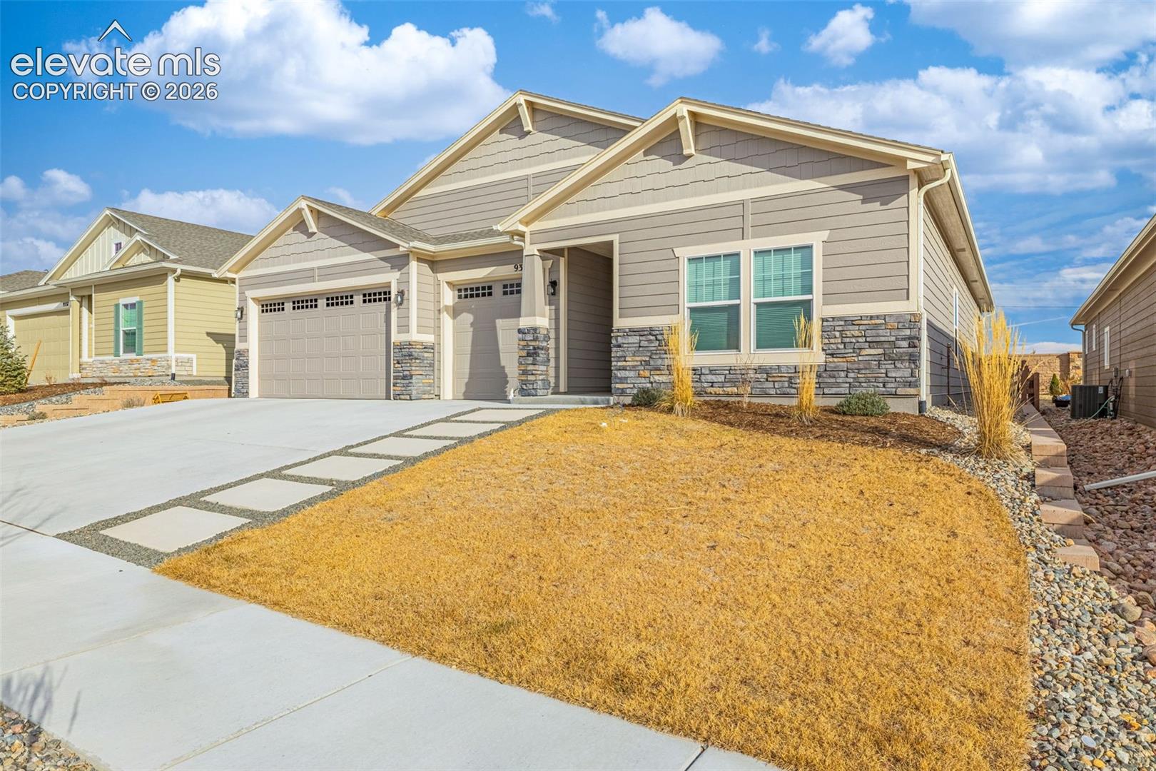 Single-story taupe home with stone facade, two-car garage, and concrete driveway.