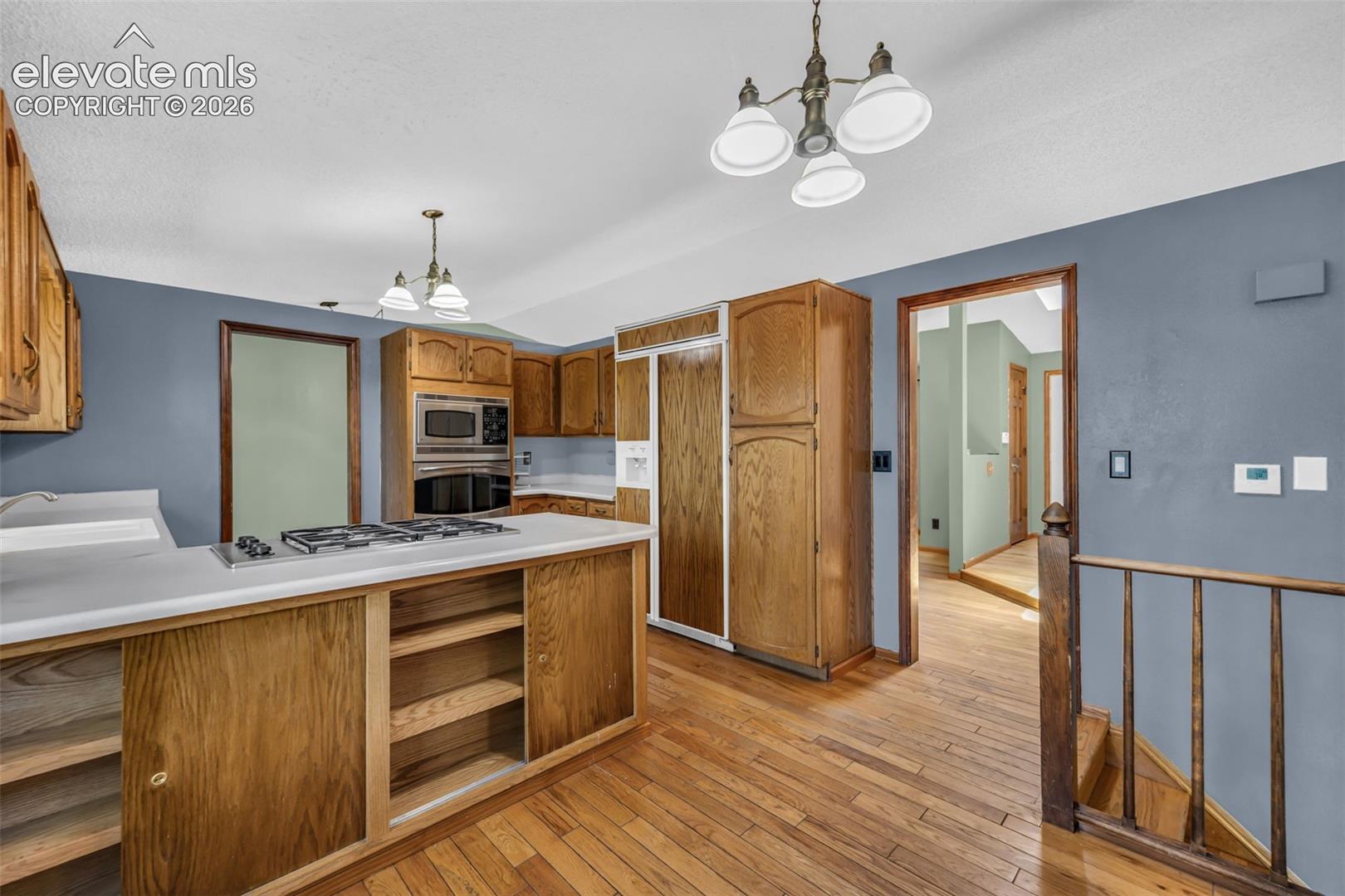 Kitchen with oak cabinets, white counters, and a gas cooktop on an island.