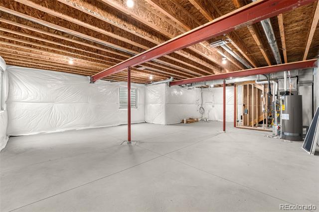 Unfinished basement with a wide concrete floor, exposed ceiling joists, and red steel support beams.