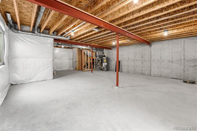 Unfinished basement with a concrete floor, exposed joists, and red steel support beams.