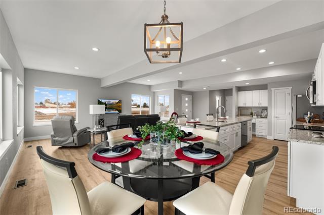 Open-plan dining room with a set glass table, living area, and kitchen.