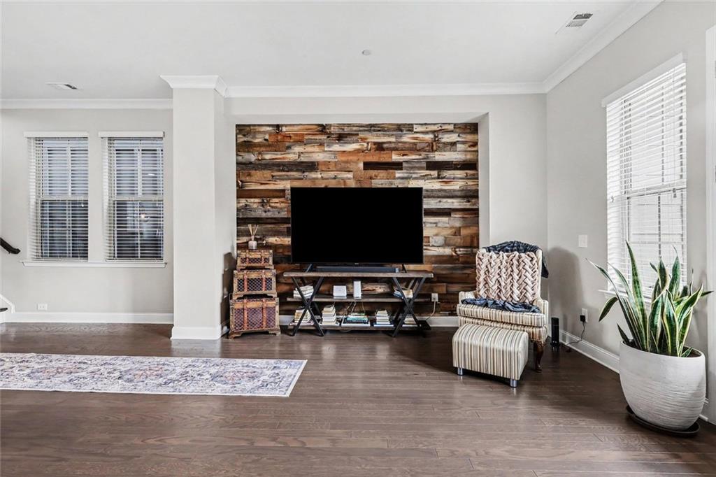 Living room with a television on a reclaimed-wood accent wall and a striped chair.