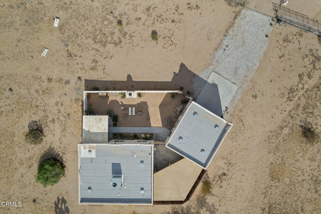 Aerial view of a desert home with a walled courtyard and gravel drive.