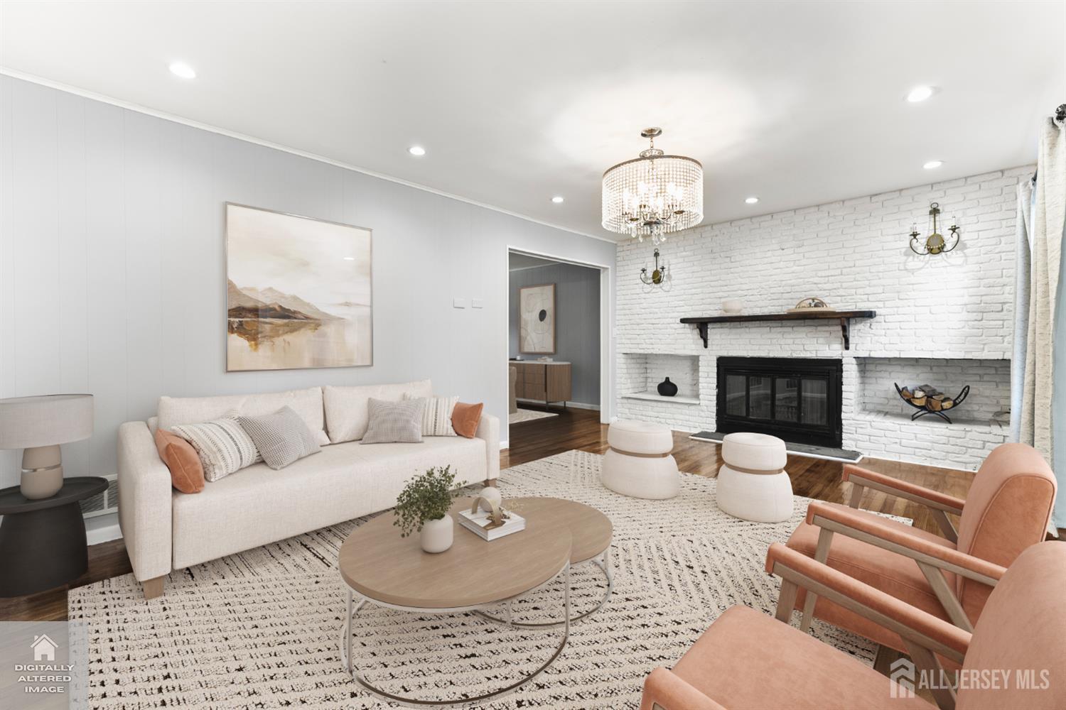 Furnished living room with a white brick fireplace, crystal chandelier, and cream and peach seating.