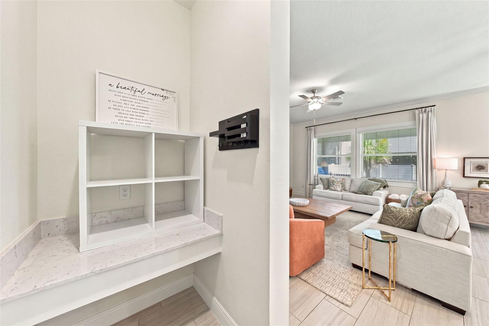 Living room with cream sofas, a wooden coffee table, and adjacent built-in shelving.