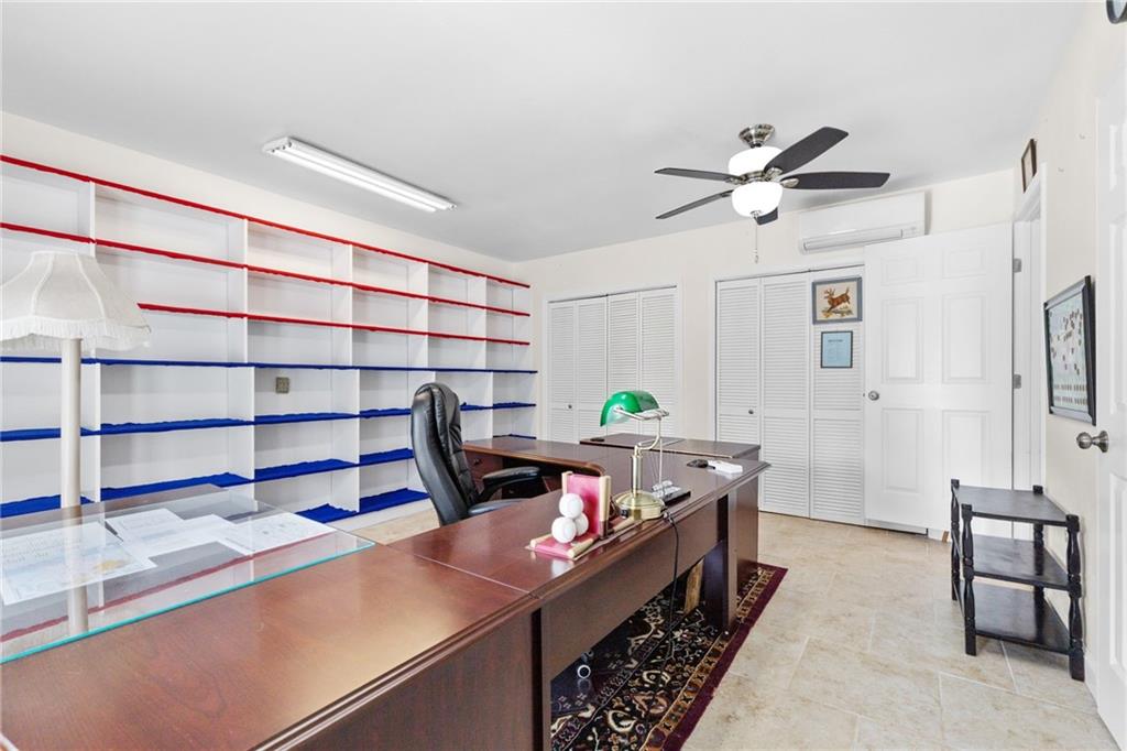Office with a large wooden desk and built-in shelves trimmed in red and blue.