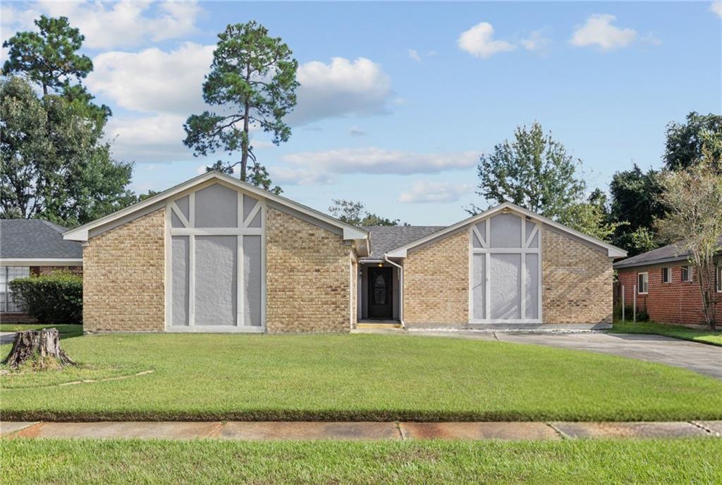 Single-story brick house with two front gables, a recessed entry, and a broad green lawn.