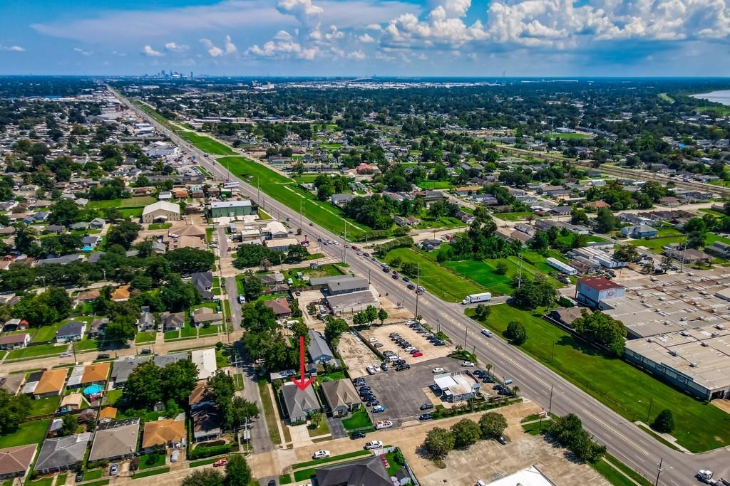 Aerial view of the property marked by a red arrow beside a major road.