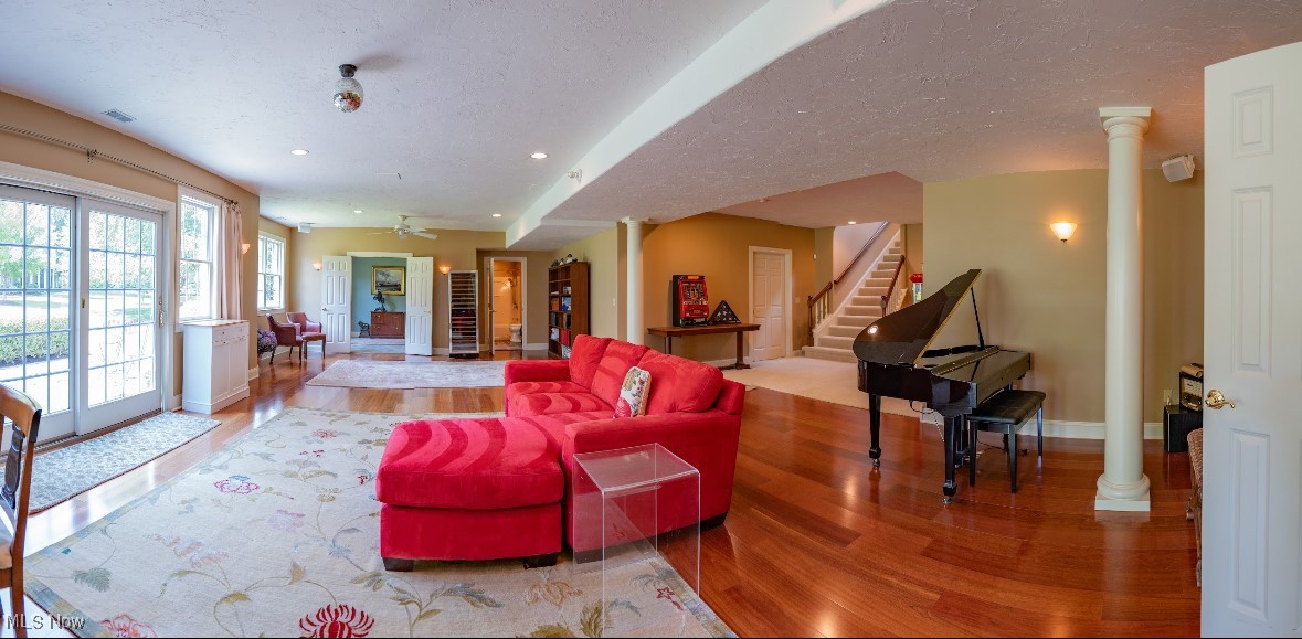 Open living room with a red sectional sofa, grand piano, and polished hardwood floors.