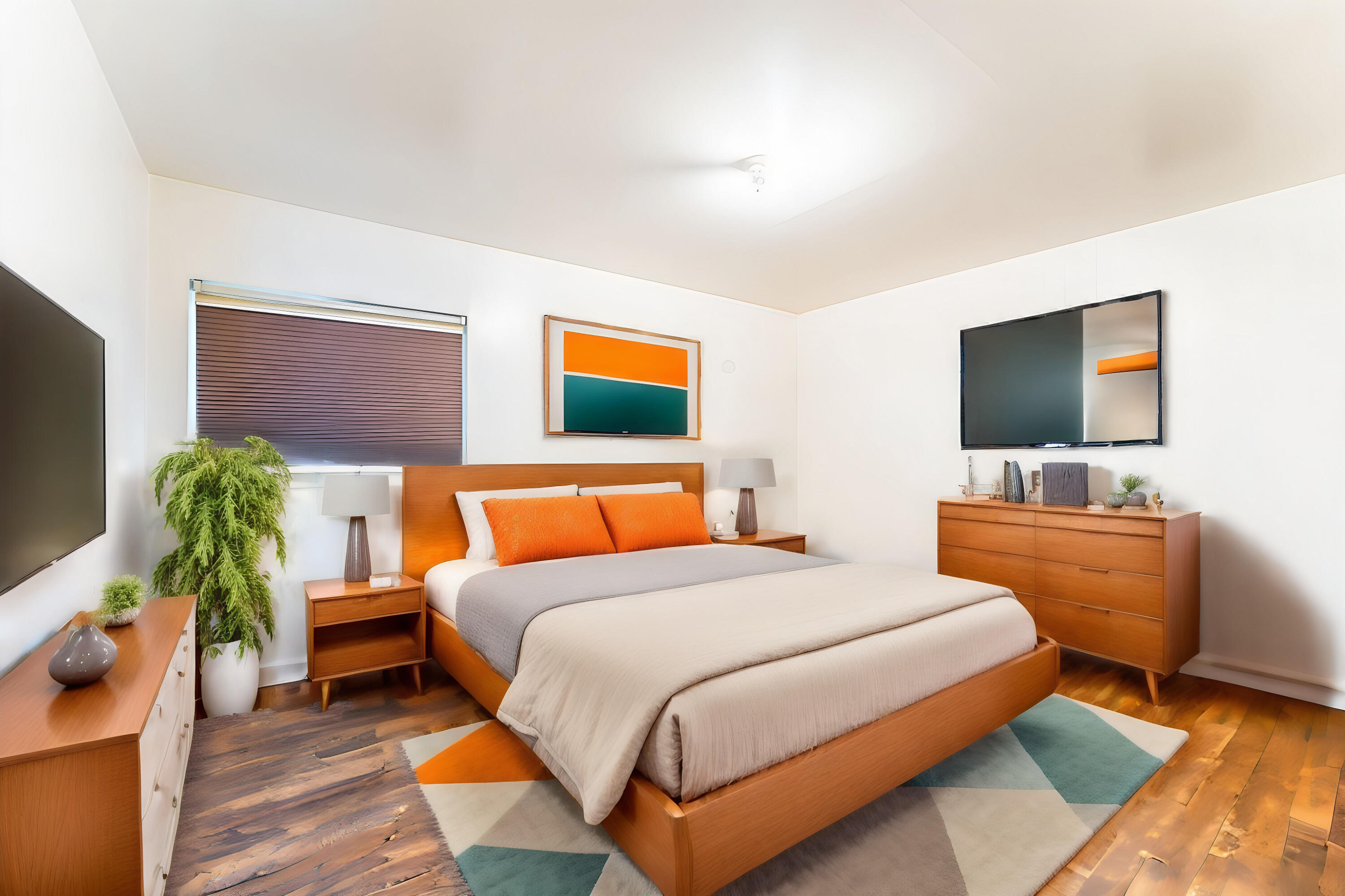 Staged bedroom with a wooden platform bed, orange pillows, matching furniture, and a geometric area rug.