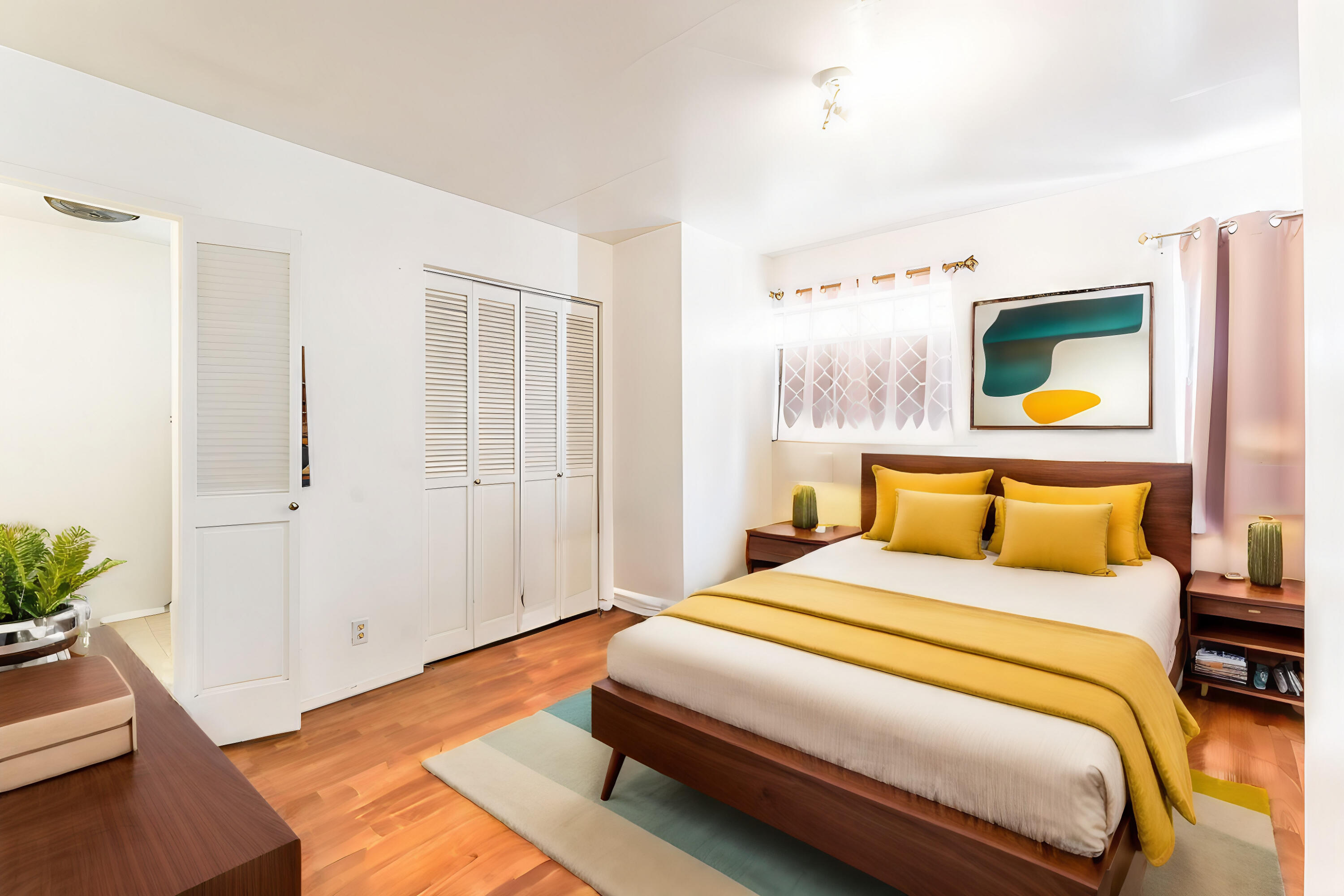 Bedroom with mustard-yellow bedding, dark wood furniture, and louvered closet doors.