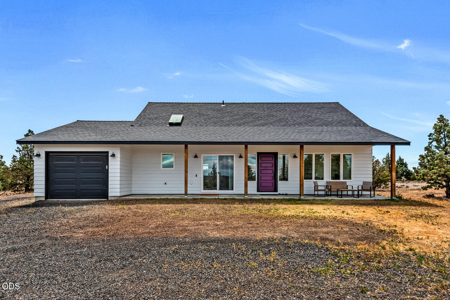 White single-story house with a black garage, covered porch, and distinctive purple front door.