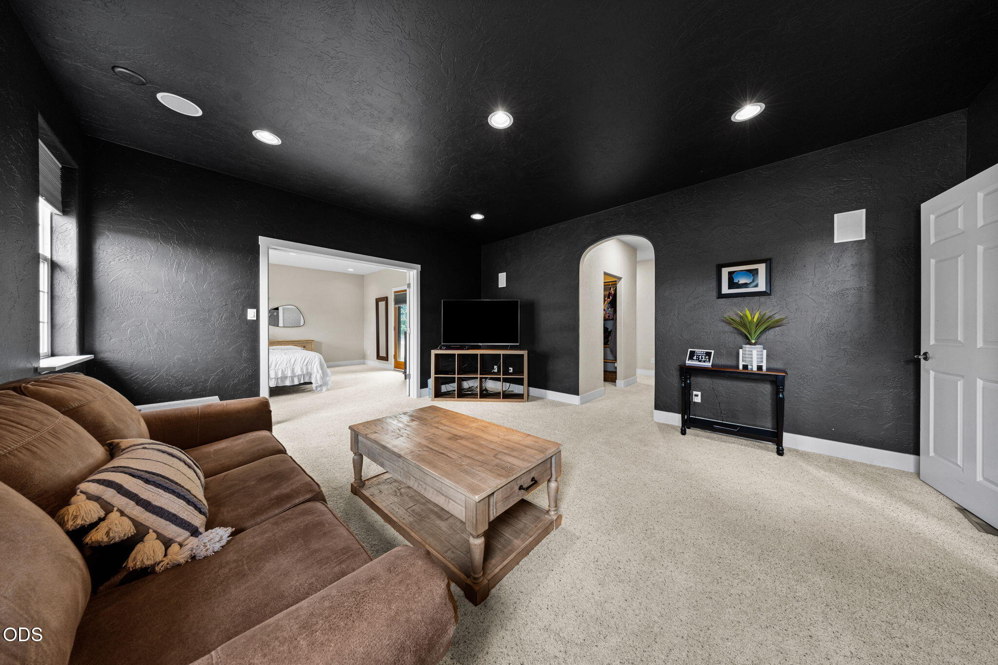 Living room with charcoal walls, a brown sectional sofa, and a wooden coffee table.
