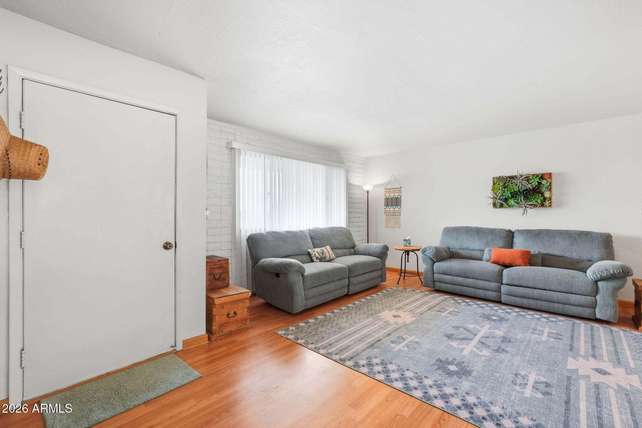 Living room with two gray sofas, a patterned rug, and warm wood floors.