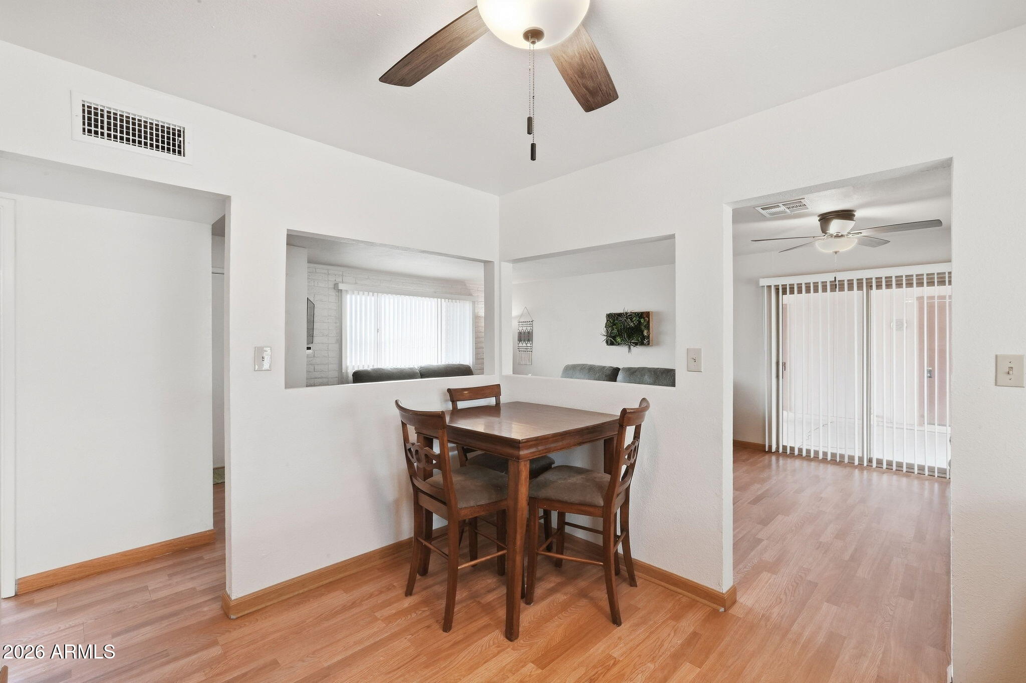 Dining area with a dark wood table and chairs beside open views into adjoining rooms.