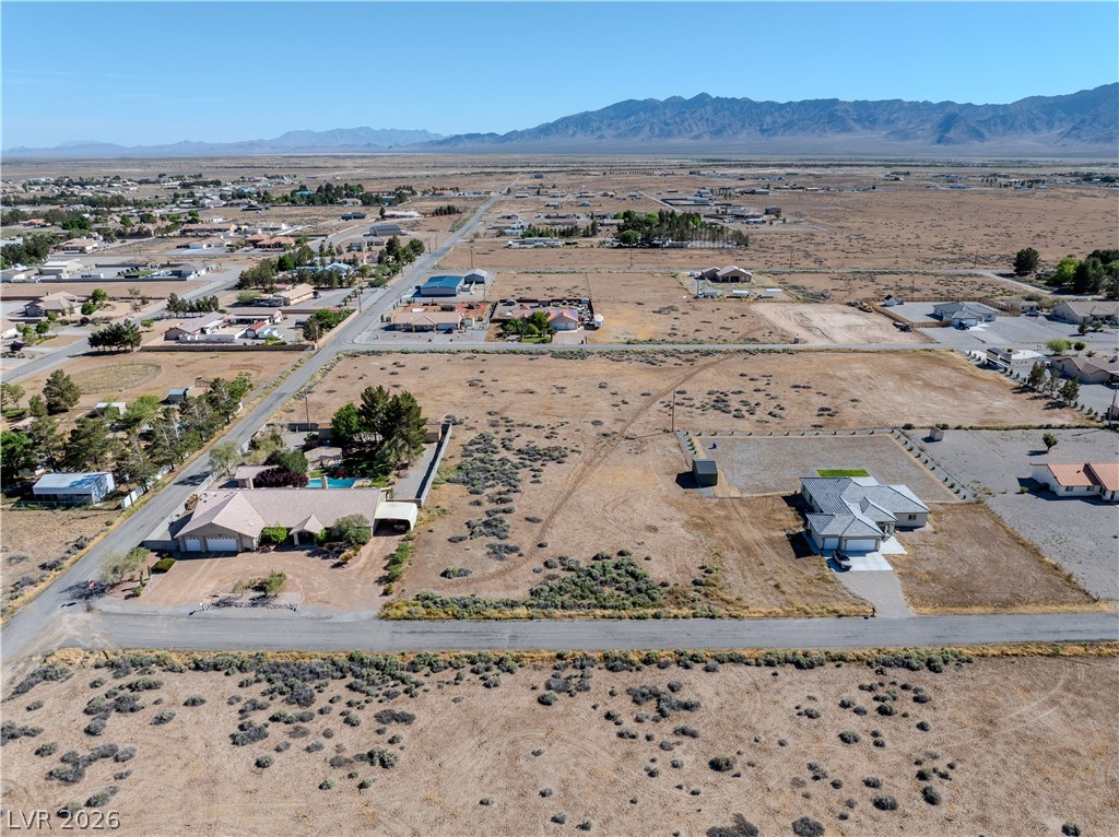 Aerial view of a dry lot in Pahrump, with scattered homes and mountains in the distance.
