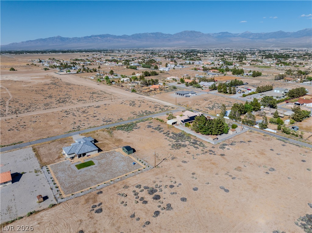 Aerial view of a home on a spacious desert lot, with Pahrump and mountains beyond.