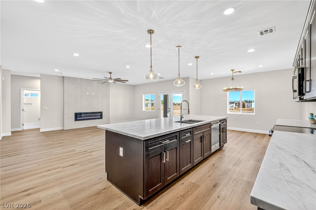 Open-plan kitchen with a large dark-wood island and a tiled fireplace in the adjoining living area.