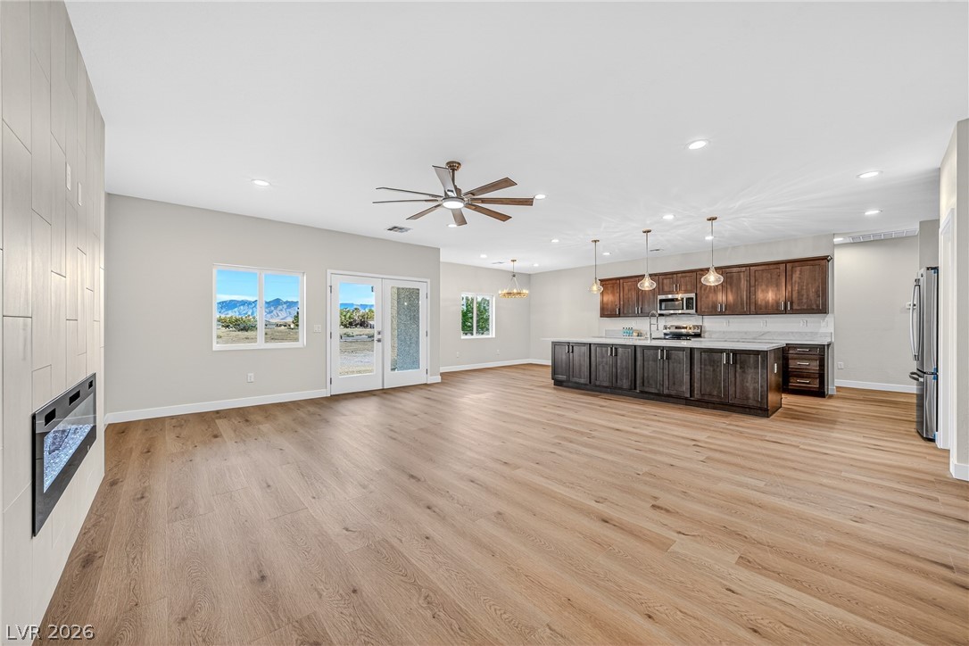 Open-plan kitchen and living area with dark cabinets, a large island, and mountain views through the windows.