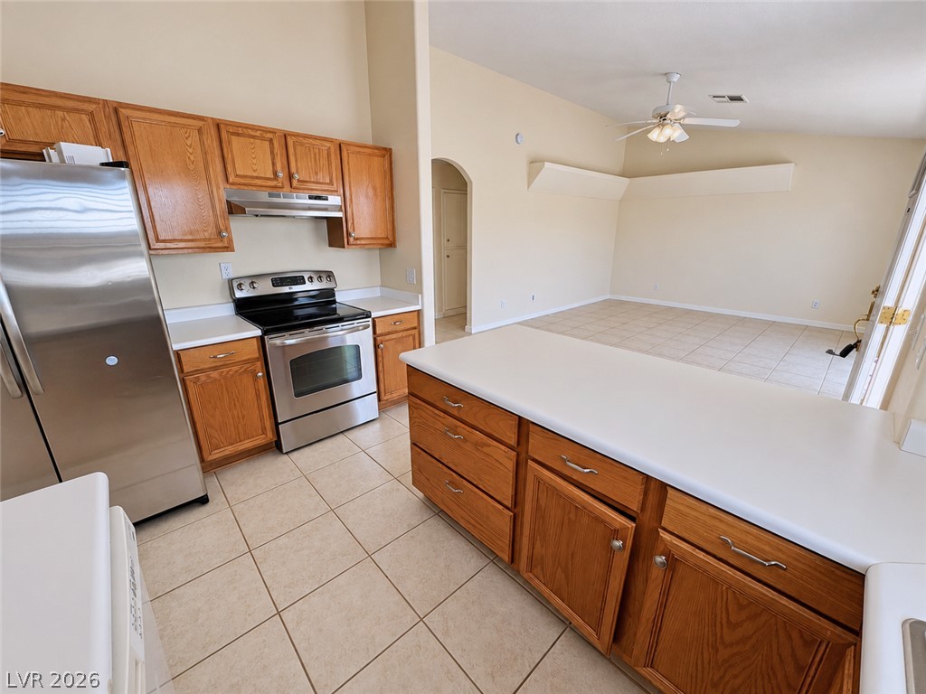 Kitchen with oak cabinets and a large island opening to a tiled dining area.