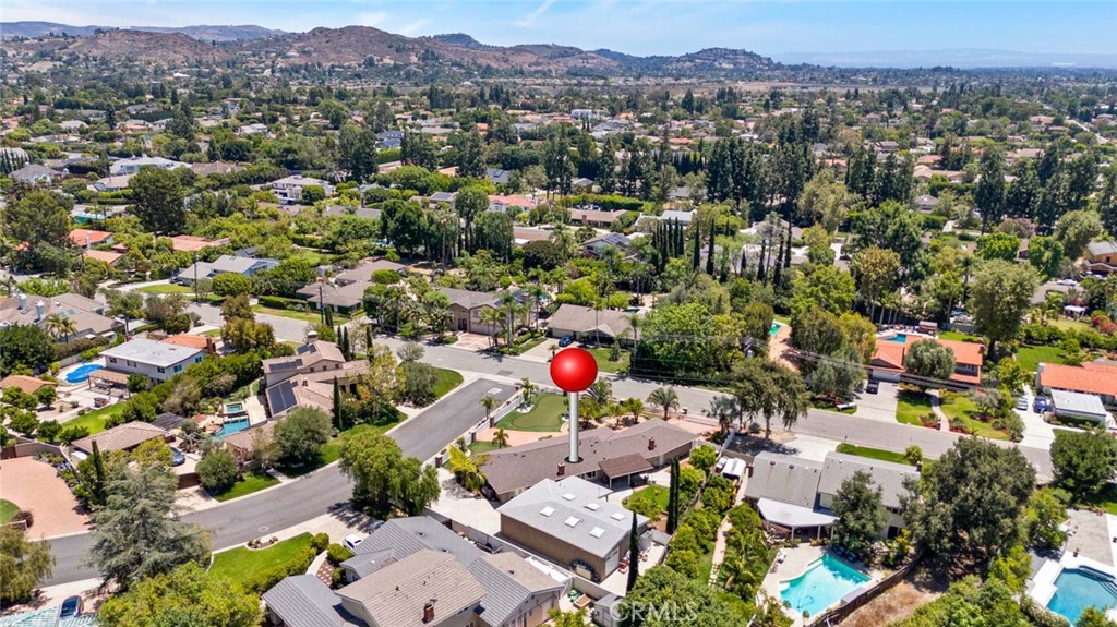 Aerial view of a Villa Park home marked with a red pin, surrounded by tree-lined streets and distant hills.