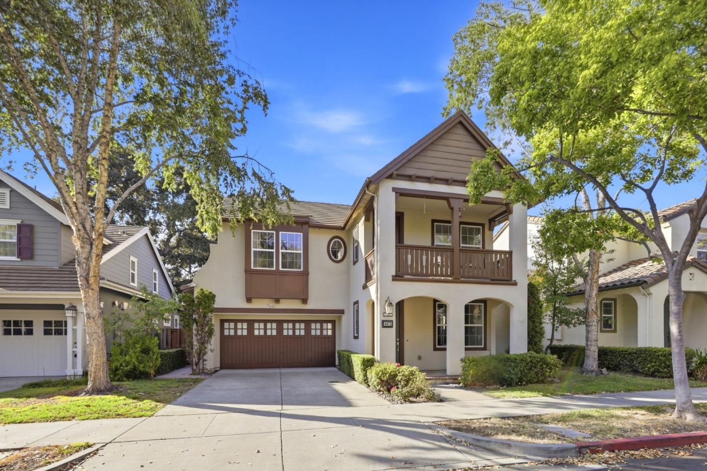 Two-story home's front exterior with a second-floor balcony, covered porch, and brown double garage.