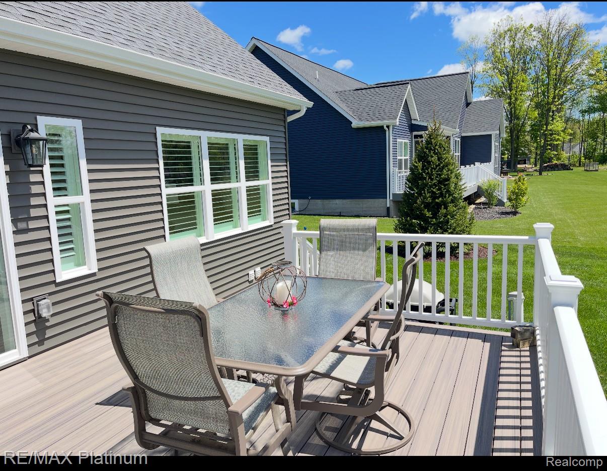 Furnished deck with a patio dining set overlooking a green lawn.