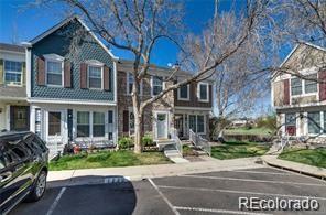 Attached two-story townhomes with blue-gray siding, white trim, and a parked car in front.