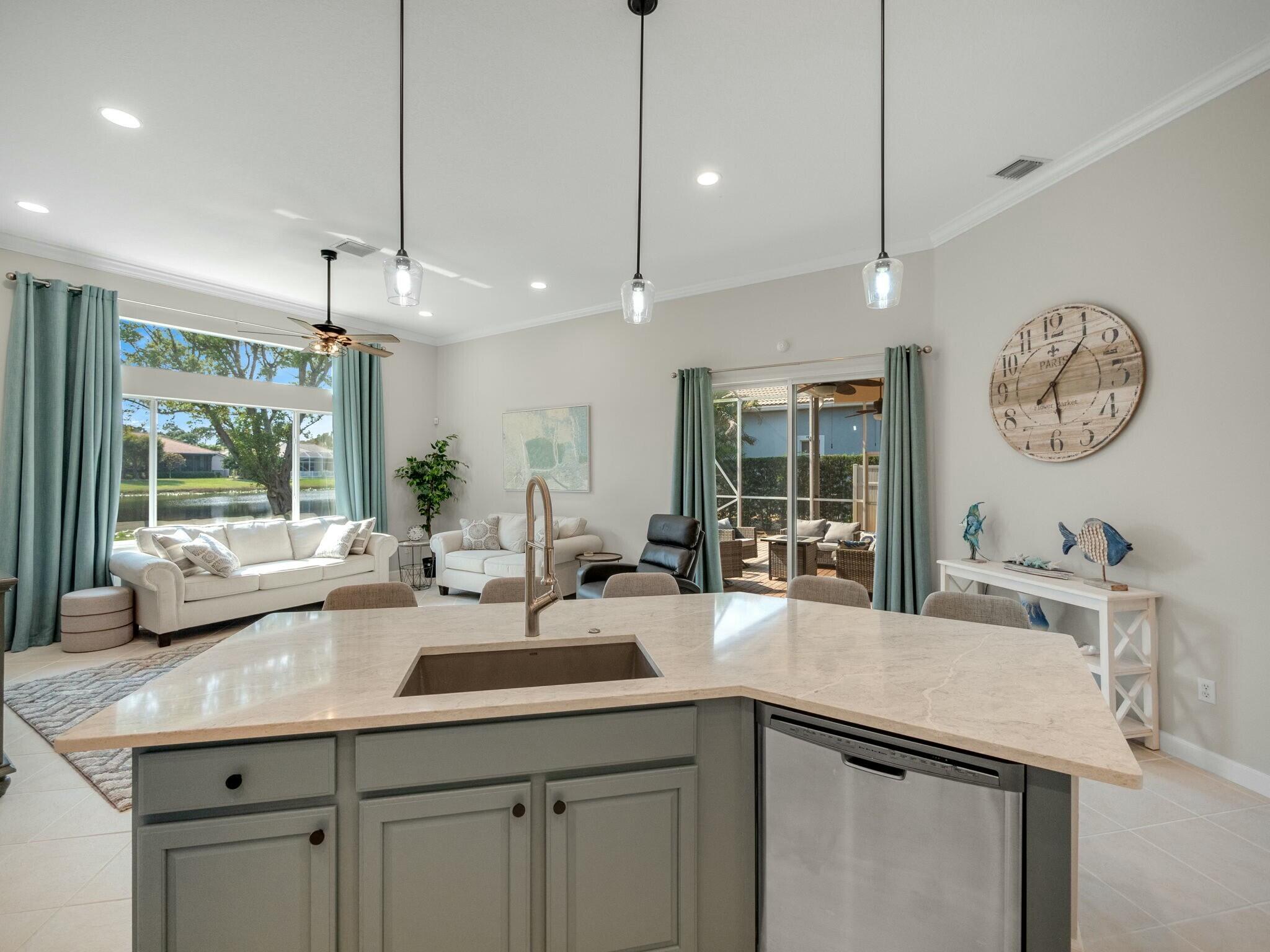Open kitchen with a large stone island and living room overlooking a canal.