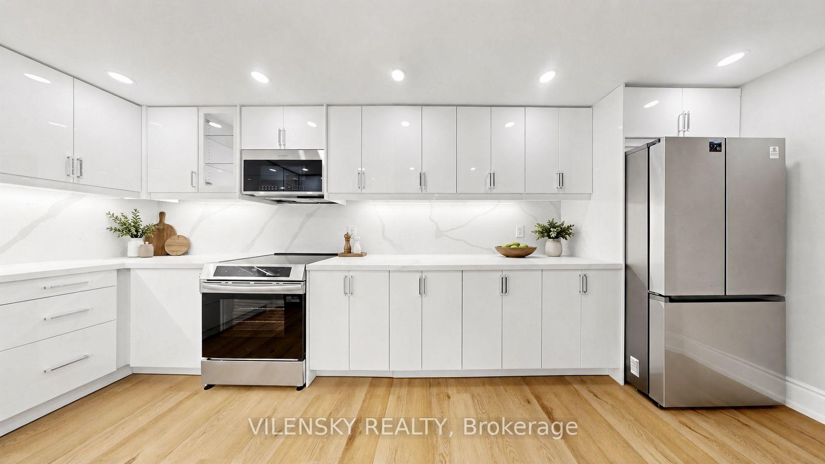 Bright white kitchen with a veined backsplash, stainless steel appliances, and light wood floors.