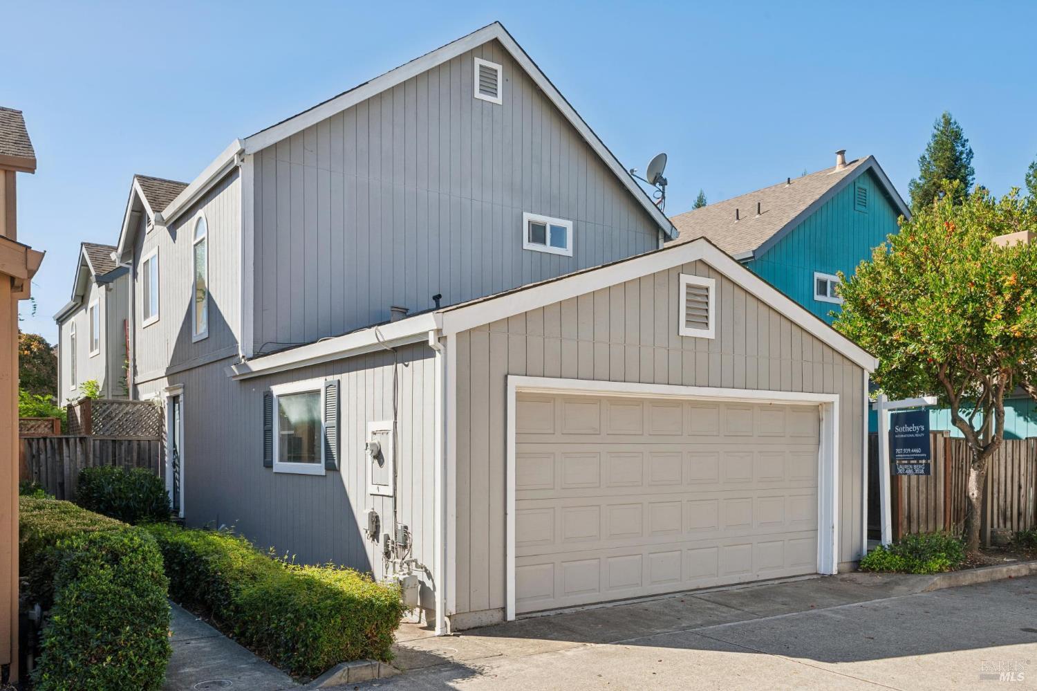 Gray multi-level home with white trim and a large attached garage.