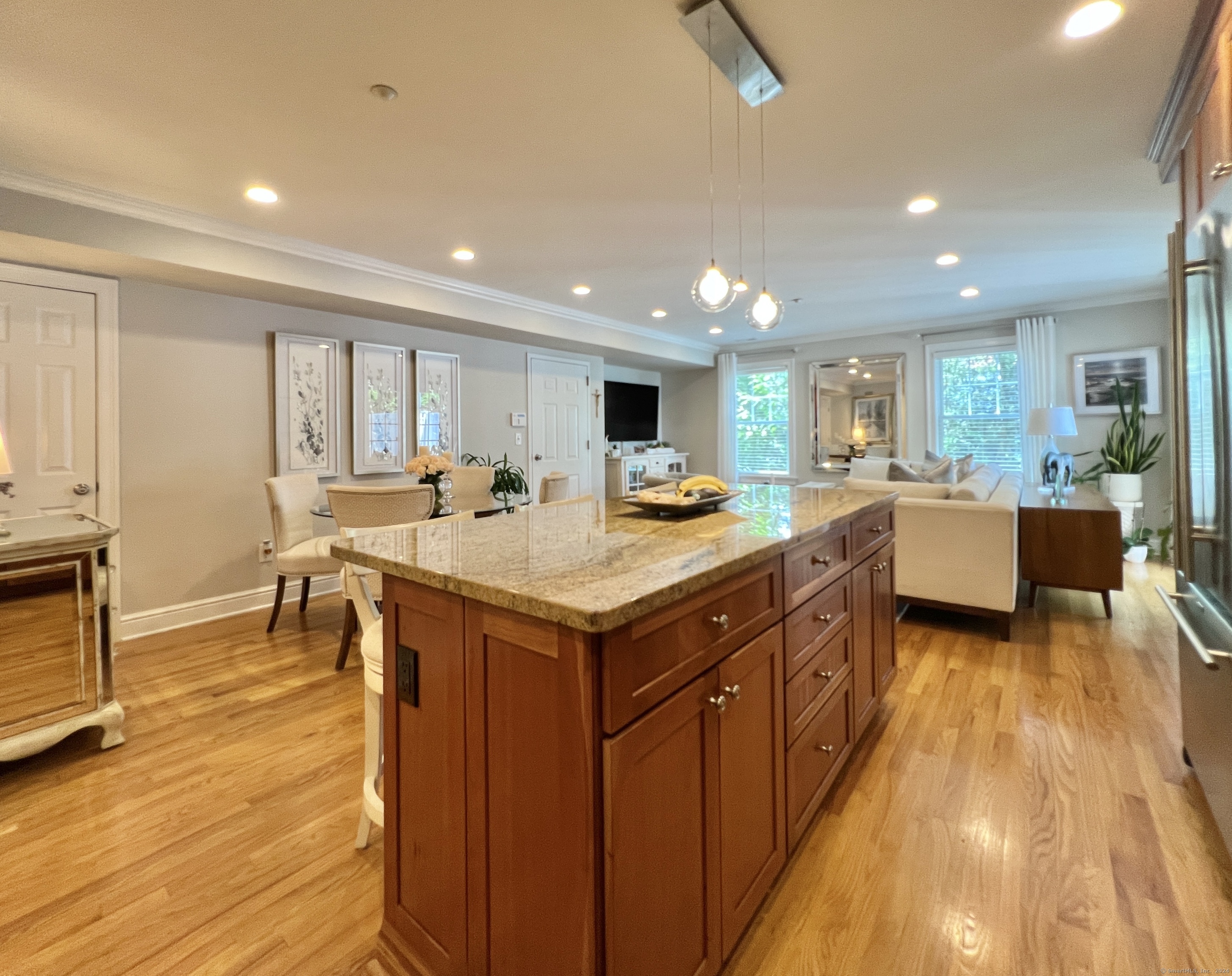 Open-plan kitchen with a large cherry island and granite countertop adjoining the dining and living areas.