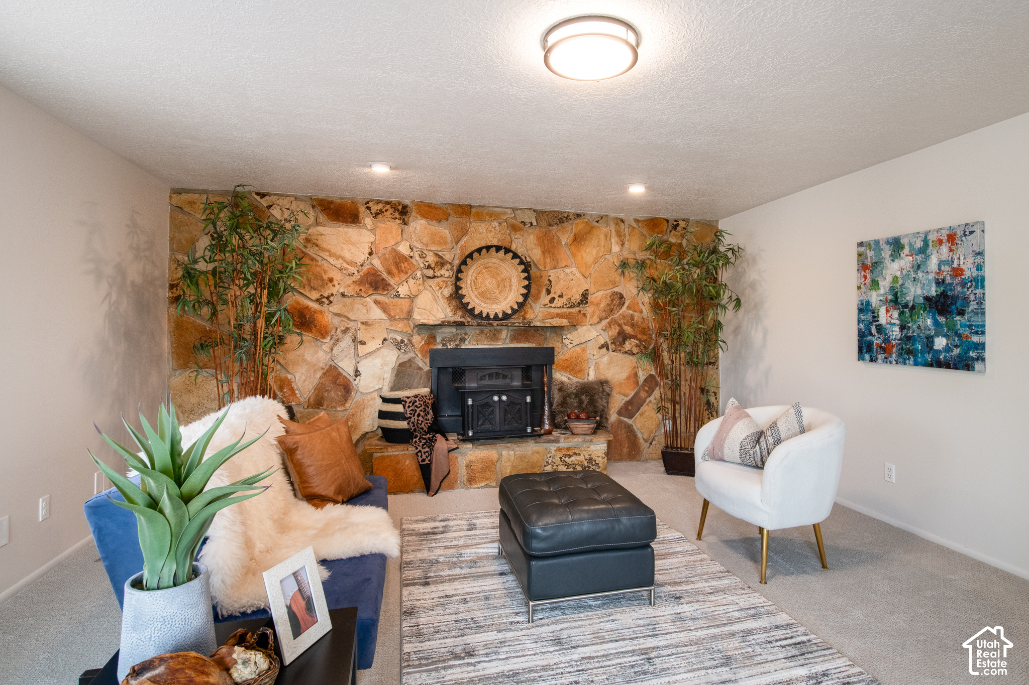 Living room with a floor-to-ceiling stone fireplace and a blue sofa.