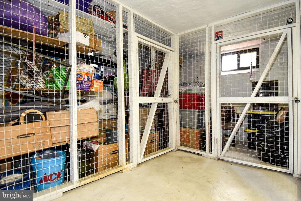 Caged storage area with wire-mesh partitions, shelves, and stored boxes.
