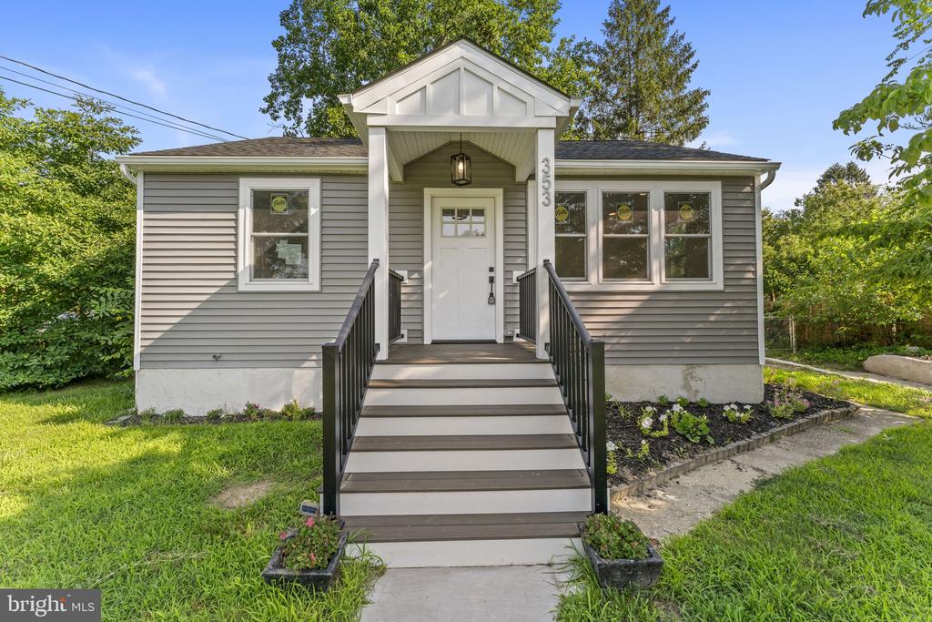 Gray single-story home with a covered entry and broad front steps with black railings.