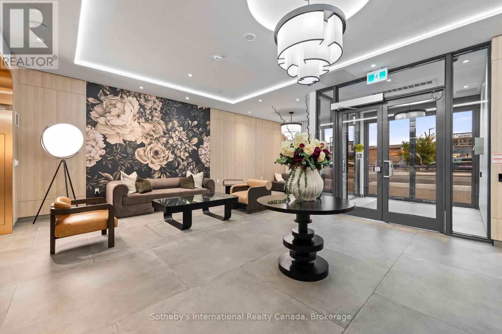 Condominium lobby with lounge seating, a floral feature wall, and a flower arrangement on a round table.