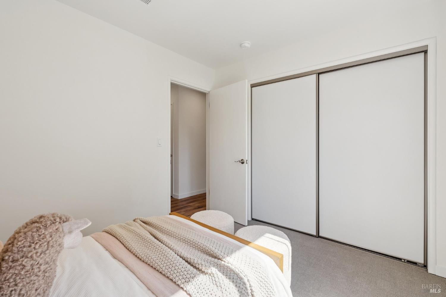 Staged bedroom with layered knit bedding and a large sliding-door closet.
