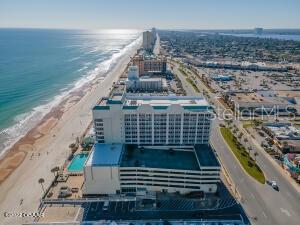 Beachfront condominium buildings along Daytona Beach, with the Atlantic shoreline and coastal road.