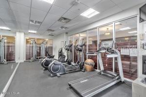 Fitness room with treadmills, stationary bikes, and weight-training equipment behind glass walls.